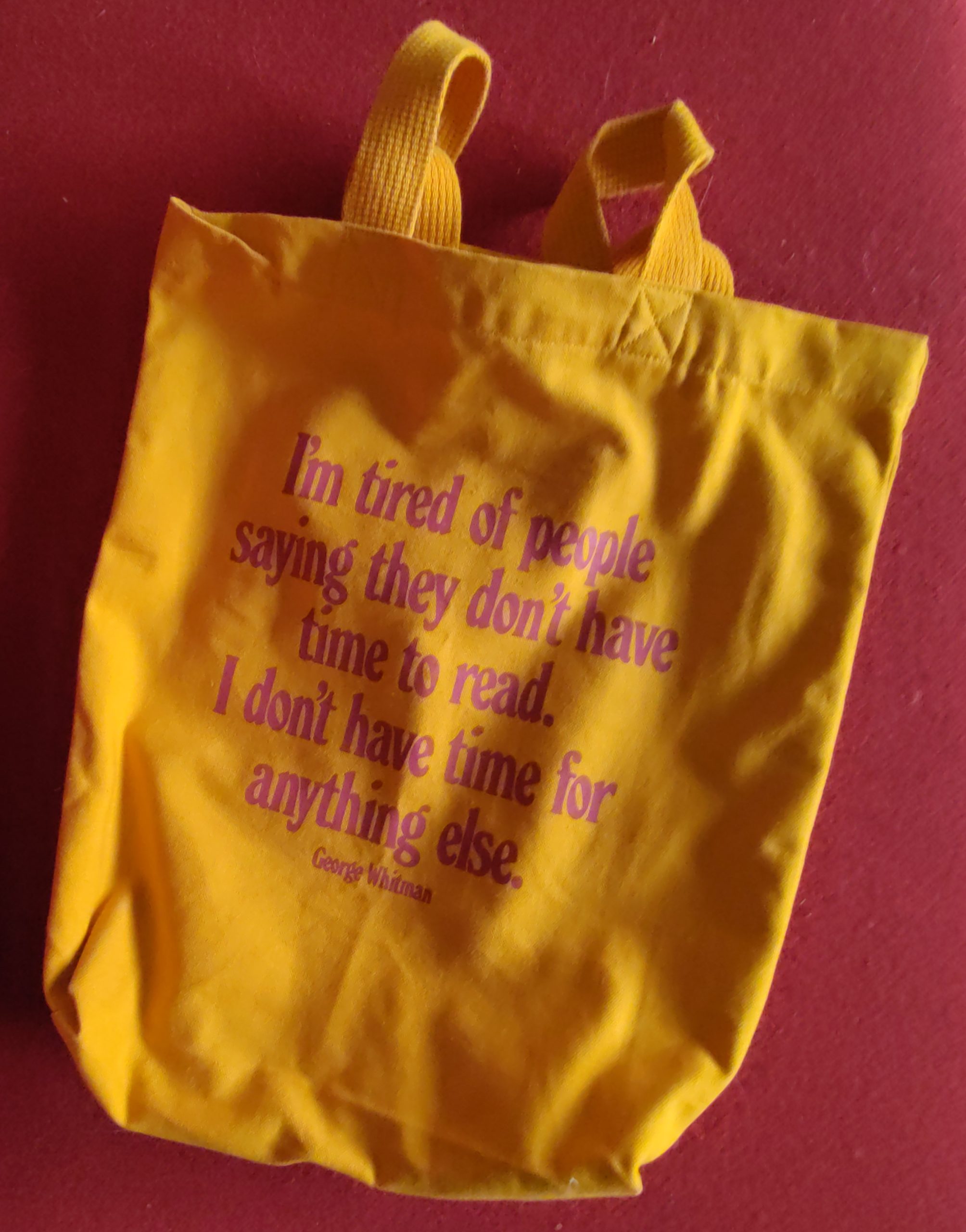 Gele linnen tas van de Parijse boekhandel Shakespeare and Company met in rode letters een citaat van George Whitman: I'm tired of people saying they don't have time to read. I don't have time to do anything else.
